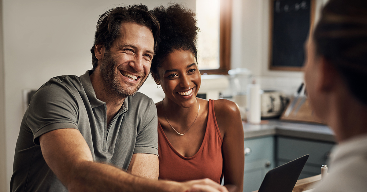A young professional couple smiles confidently, exuding positivity and teamwork in a business-focused setting.