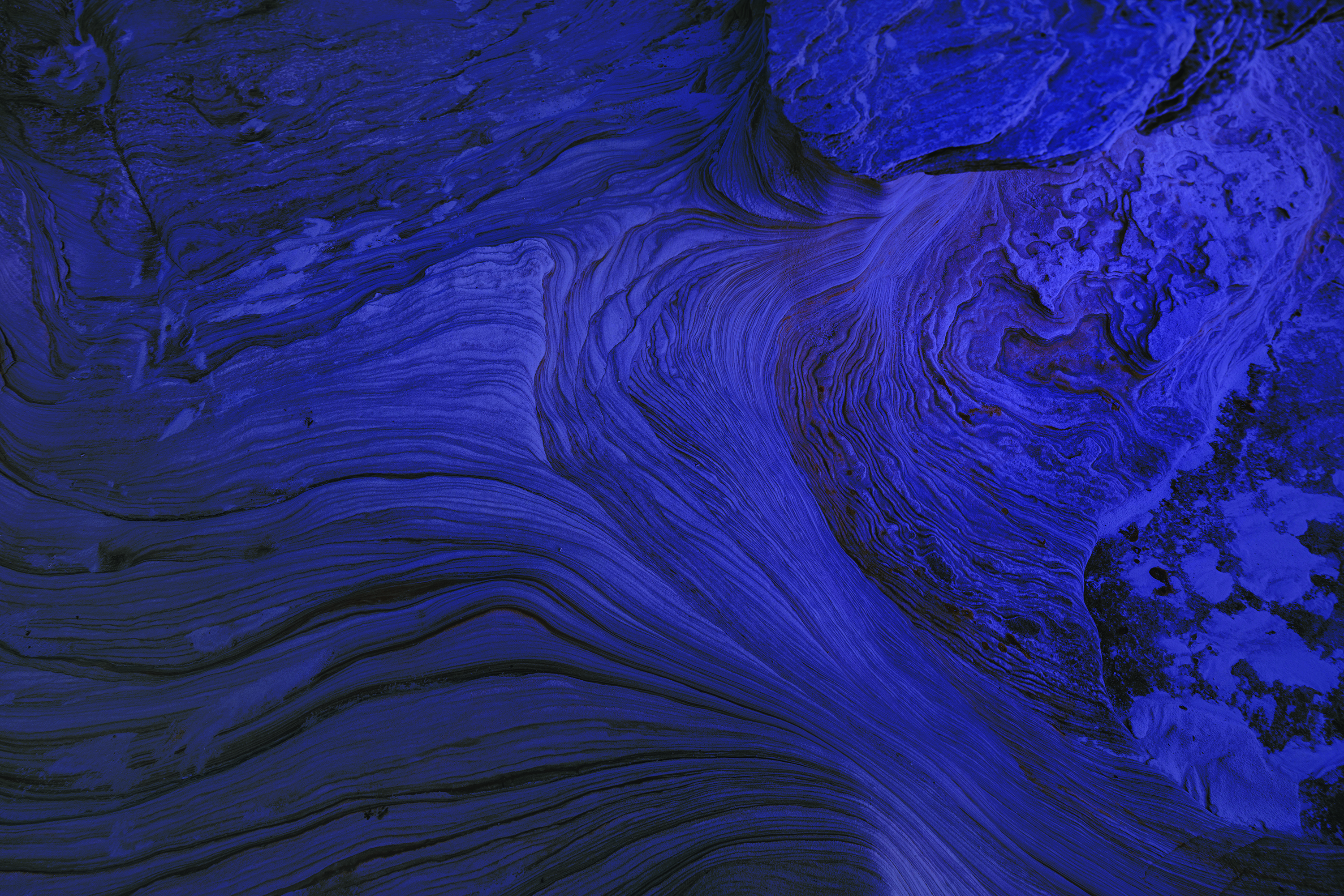 Ce design de papier peint abstrait présente un motif captivant, mélangeant des textures de lumière et d'eau sur un fond bleu.