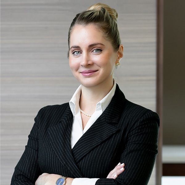 A professional portrait of a young businesswoman in a formal setting, showcasing confidence and a focused demeanor.