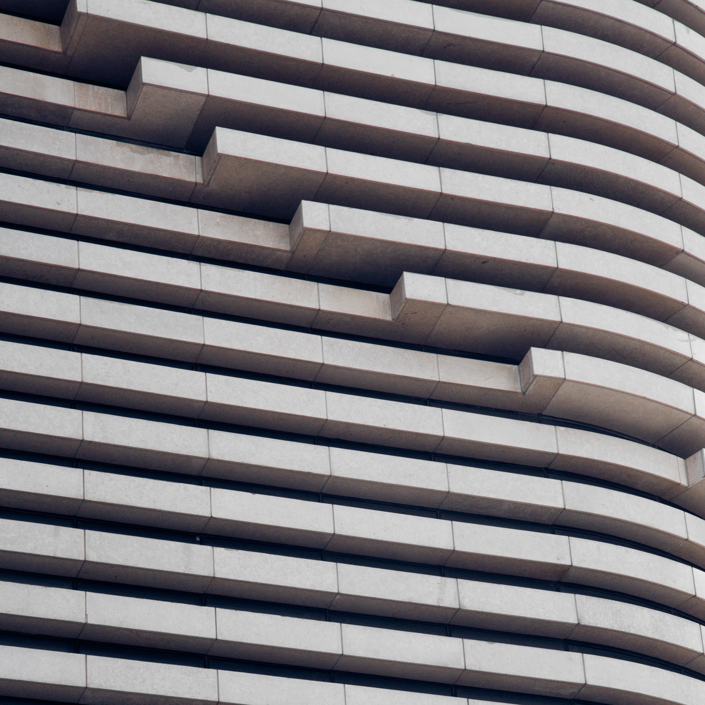 Le design met en avant un motif de stores en acier bleu, créant une texture abstraite avec des lignes métalliques sur un fond.